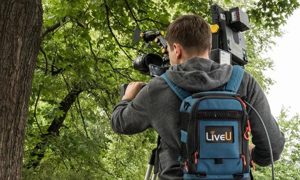 Operador de cámara con mochila LiveU en producción exterior